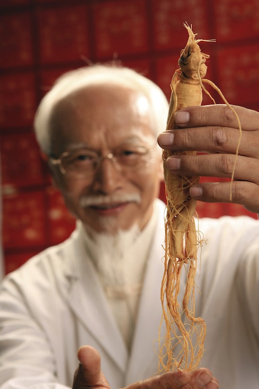 Chinese Doctor holding Ginseng